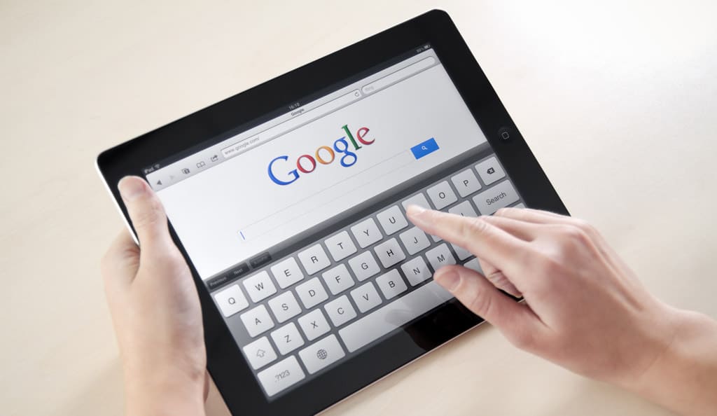 close up of hands doing a Google search on iPad