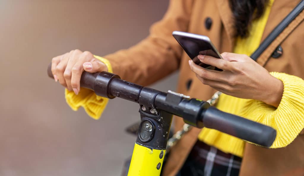 woman doing a search on phone while on scooter