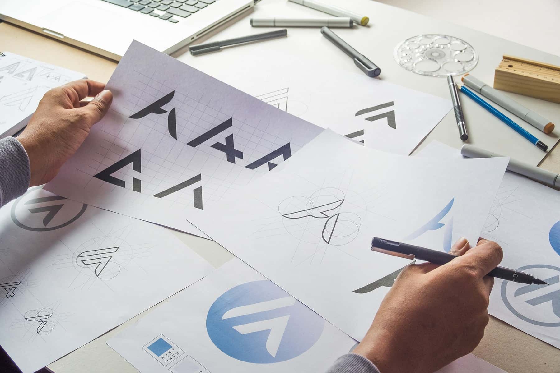 a view of a desk full of logo design mockups