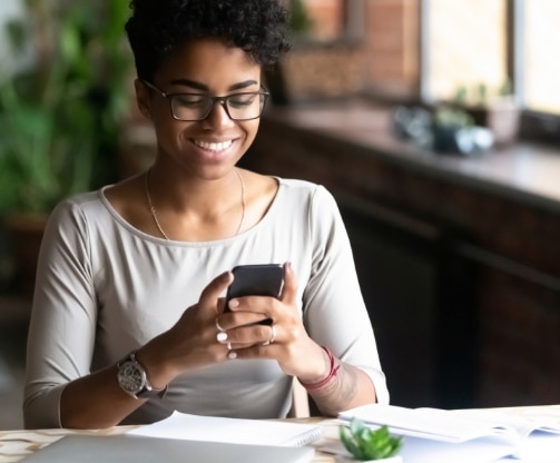 a woman looking at a phone screen and smiling