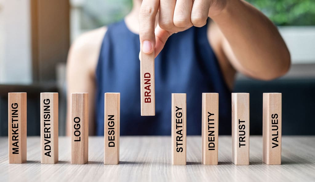 businesswoman placing wooden blocks with brand text on them