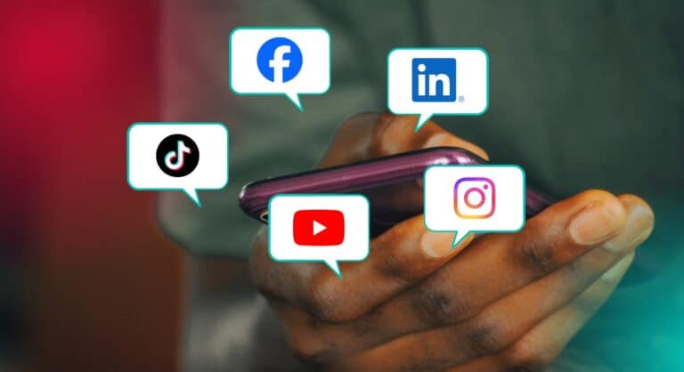 a hand holding a phone with social media icons Facebook, LinkedIn, Instagram, YouTube, and TikTok floating around it