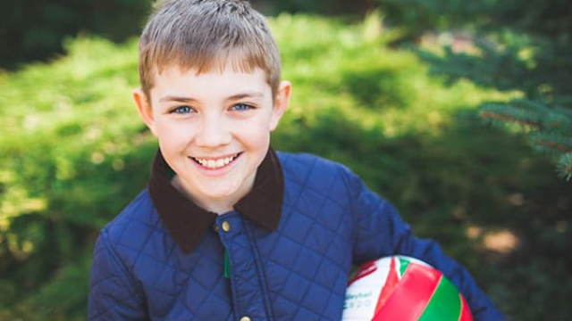 a young boy holding a volleyball