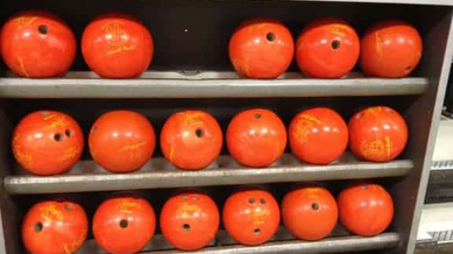 a rack of orange bowling balls