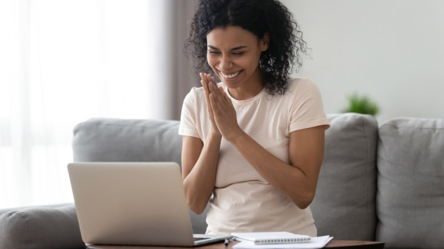 woman looking at laptop and happy about great website experience