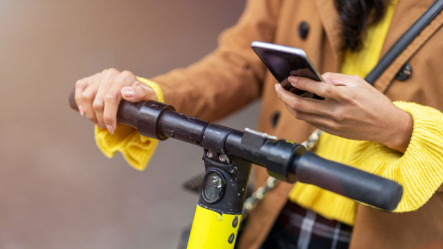 woman doing a search on phone while on scooter