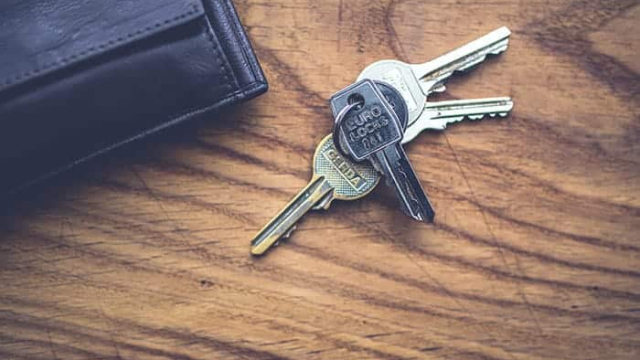 a picture of a set of keys and a wallet on a wooden table