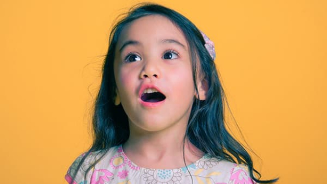 a little girl with a surprised look on her face