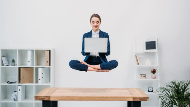 woman using a laptop while floating above desk