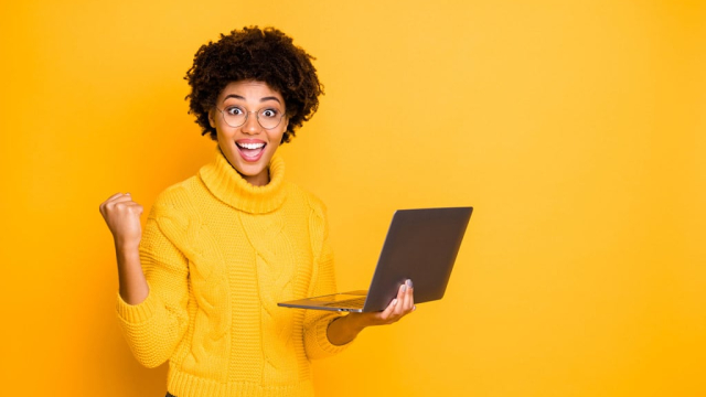 woman holding laptop with a winning smile